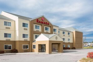 Un hotel Ramada de varios pisos con fachada color beige, numerosas ventanas y una entrada central.