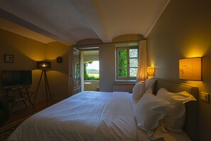 Una habitació d'hotel amb un llit, una taula de treball, una làmpada i una finestra amb vistes.