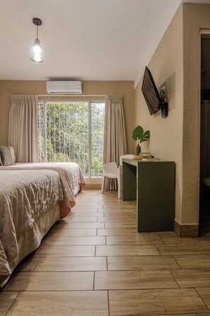 Un dormitorio con cama, escritorio, silla y ventana con cortinas.