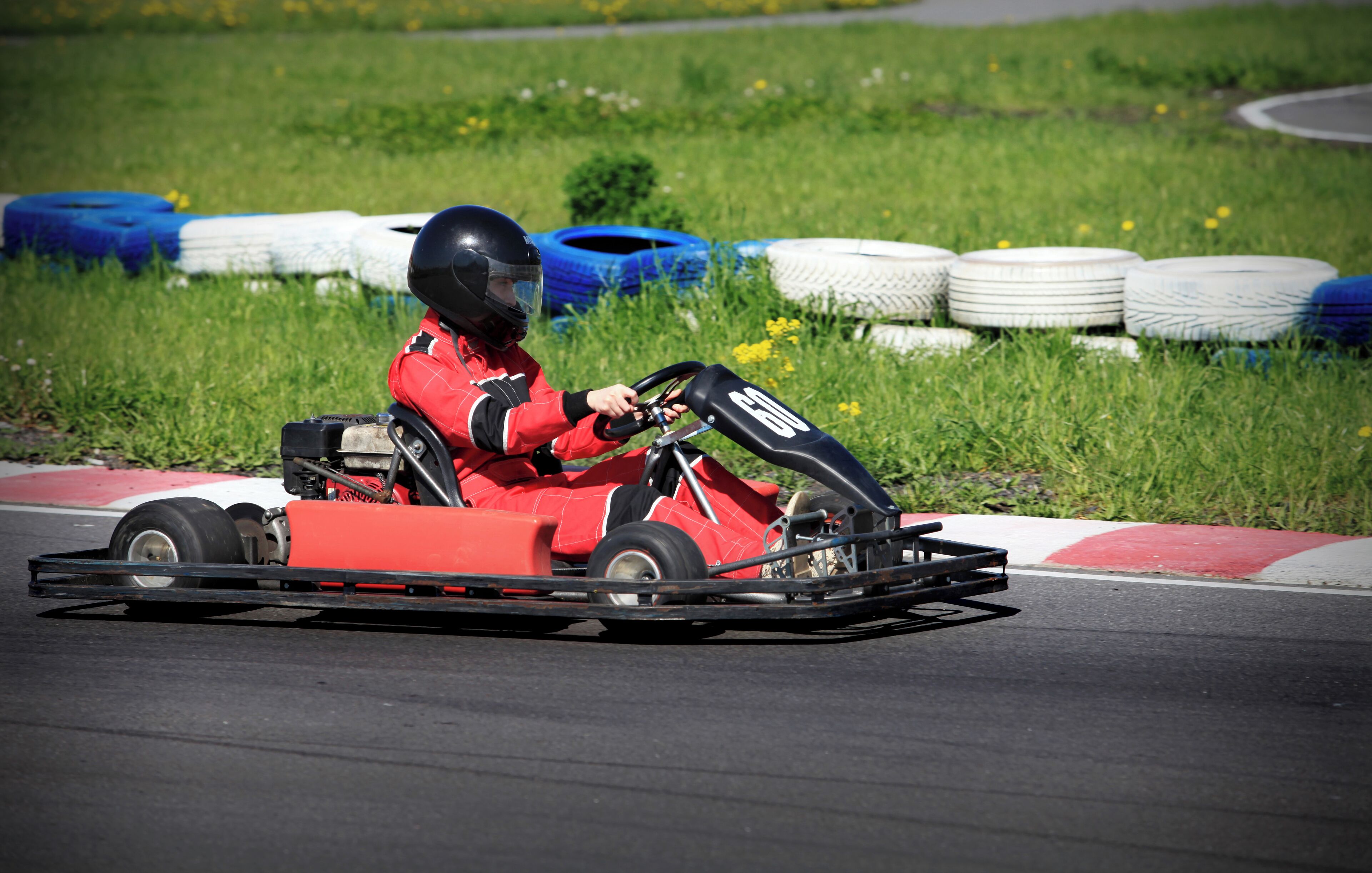 Een raceauto op een circuit met een bestuurder in rode kleding.