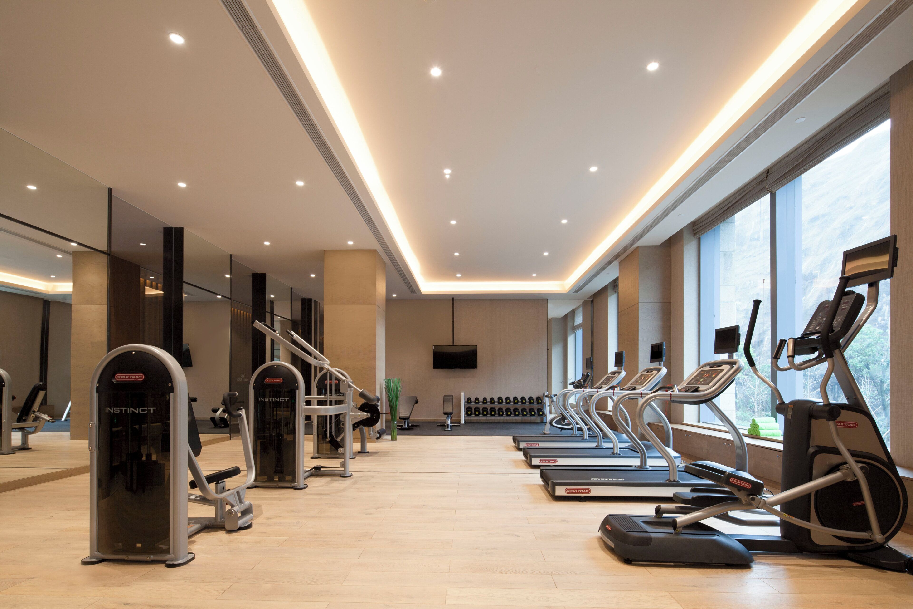 Academia com esteiras, elípticos e equipamentos de musculação.