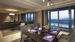 A dining area with a large table set for six, a bar area, and a view of the sea. - Crowne Plaza Hangzhou Thousand Island Lake by IHG (Hangzhou)