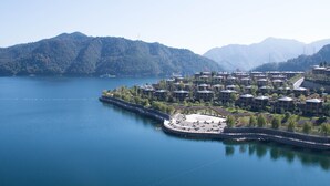 A lakeside resort with a marina, surrounded by forested mountains. - Crowne Plaza Hangzhou Thousand Island Lake by IHG (Hangzhou)