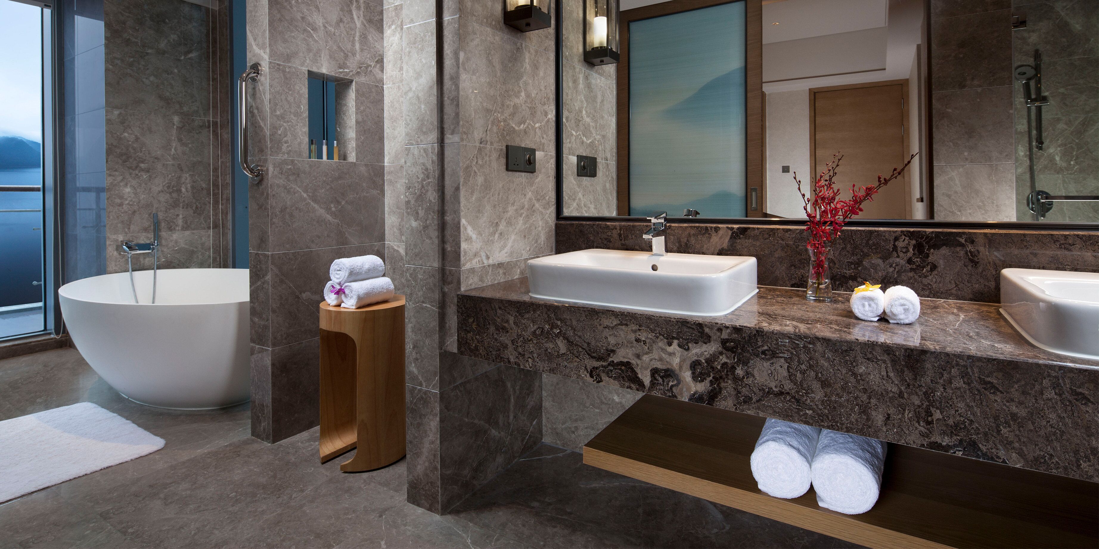 A modern bathroom with a freestanding bathtub, a vanity with a sink, and a mirror.