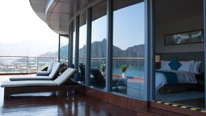 A modern room with a large window, a bed, and a seating area with a view of the mountains. - Crowne Plaza Hangzhou Thousand Island Lake by IHG (Hangzhou)