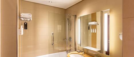 A modern bathroom with a glass-enclosed shower, a standalone bathtub, and a vanity with a large mirror.