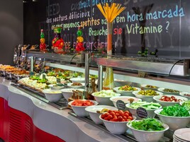 Un bufé con diversos alimentos y una pizarra con texto en un idioma extranjero.