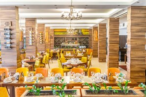 Ein Restaurant mit Holzwandverkleidung, gelben Stühlen und gedeckten Tischen.