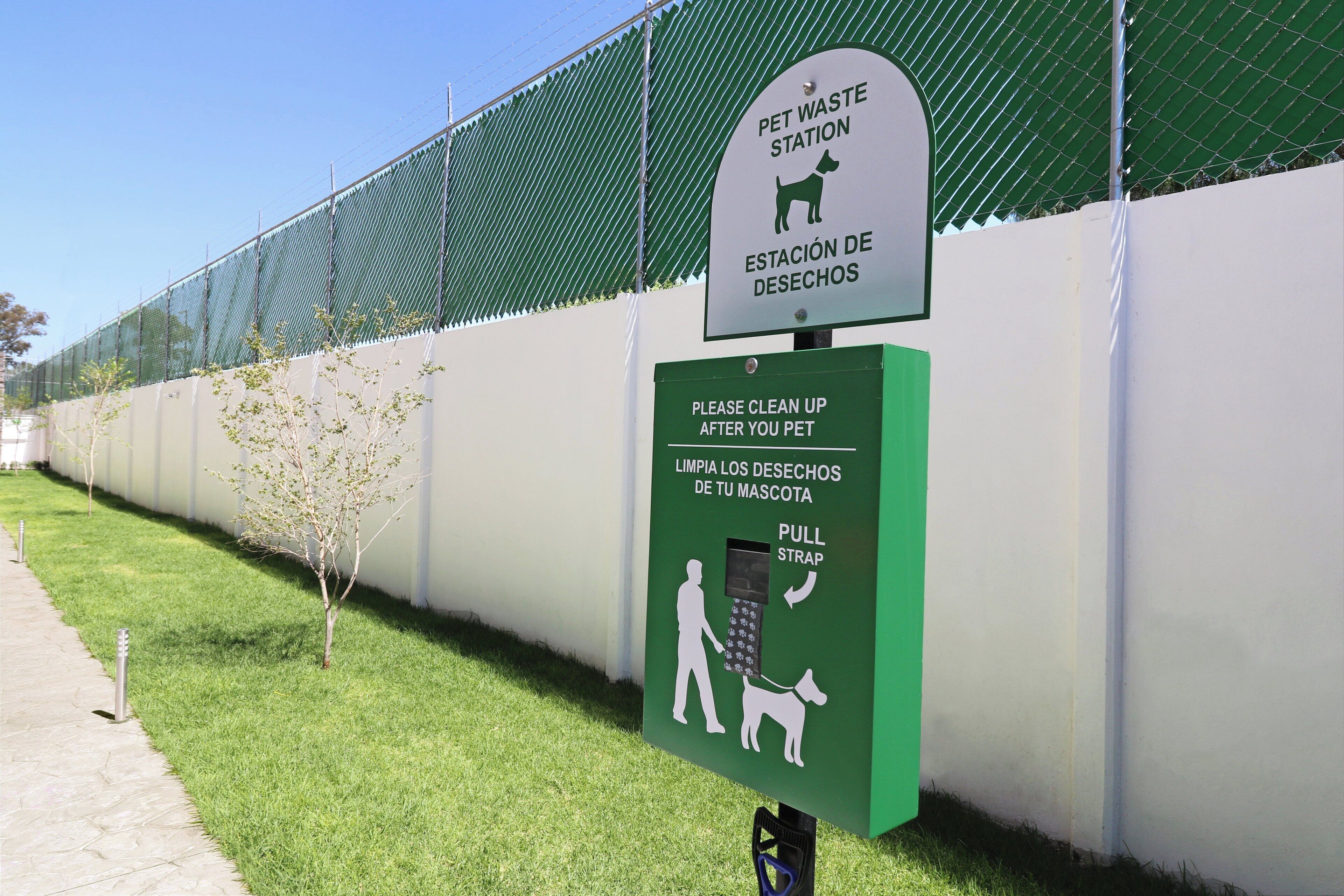 Un poste de collecte des excréments d’animaux de compagnie, muni d’instructions bilingues pour faciliter le nettoyage.