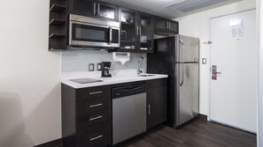 Eine moderne Küche mit einem Edelstahl-Kühlschrank, einer eingebauten Mikrowelle und einem Geschirrspüler.