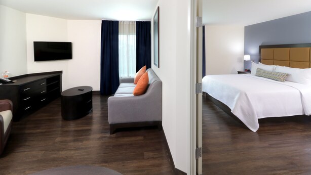 Une chambre d’hôtel équipée d’un lit, d’un canapé, d’une télévision, d’un bureau et d’une chaise.