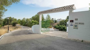 A gated entrance to a property named "Las Rosas" with a white wall and a green gate. - Conjunto Rural Las Rosas (Frigiliana)