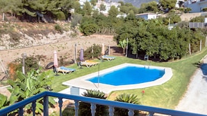 A balcony with a pool, a table with a bottle and glasses, and a view of the surrounding landscape. - Conjunto Rural Las Rosas (Frigiliana)