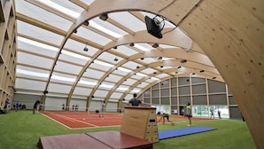 An indoor sports facility with a tennis court, a wooden climbing wall, and a green artificial turf area. - Centrum Galion (Gda?sk)