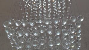 A ceiling with a hanging light fixture consisting of numerous clear glass orbs. - Hotel NG (Cartagena)