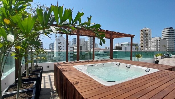 A rooftop terrace with a hot tub, wooden deck, potted plants, and a pergola. - Hotel NG (Cartagena)