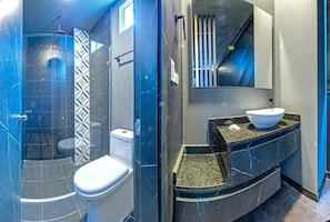 A modern bathroom with a glass-enclosed shower, a toilet, and a vanity with a sink. - Hotel NG (Cartagena)
