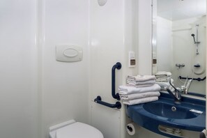 A bathroom with a white toilet, a blue sink, and a mirror. - Initial By Balladins Lyon-chanas (Chanas)