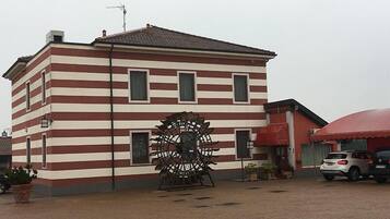 Um edifício com fachada listrada e uma grande turbina eólica na frente.