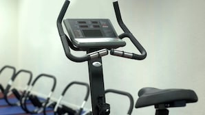 A stationary bike with a digital display, a seat, and a control panel.