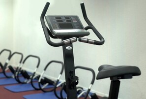 Una bicicleta estática con pantalla digital, un asiento y un panel de control.