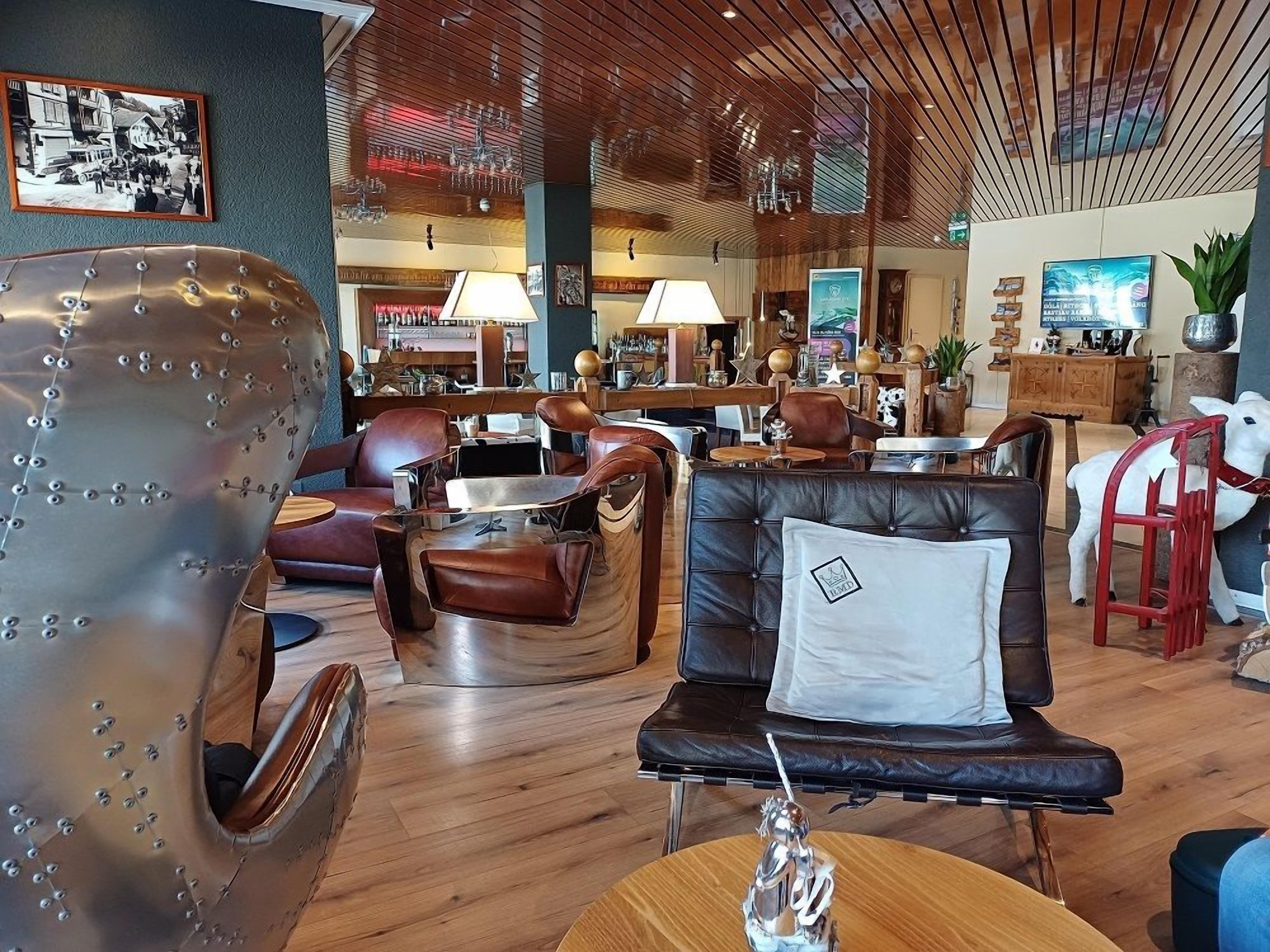 Ein moderner Lounge-Bereich mit Ledersofas, einer Bar und einer Holzbalkendecke.