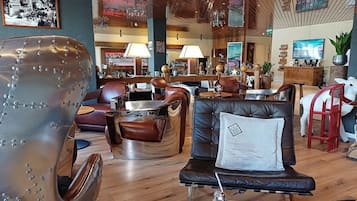 Ein moderner Lounge-Bereich mit Ledersofas, einer Bar und einer Holzbalkendecke.