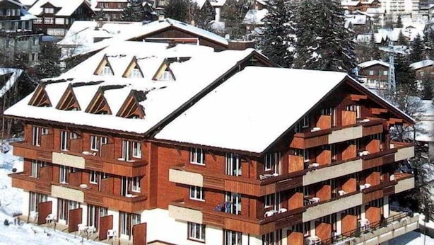 A multi-story hotel with balconies and a snow-covered roof.