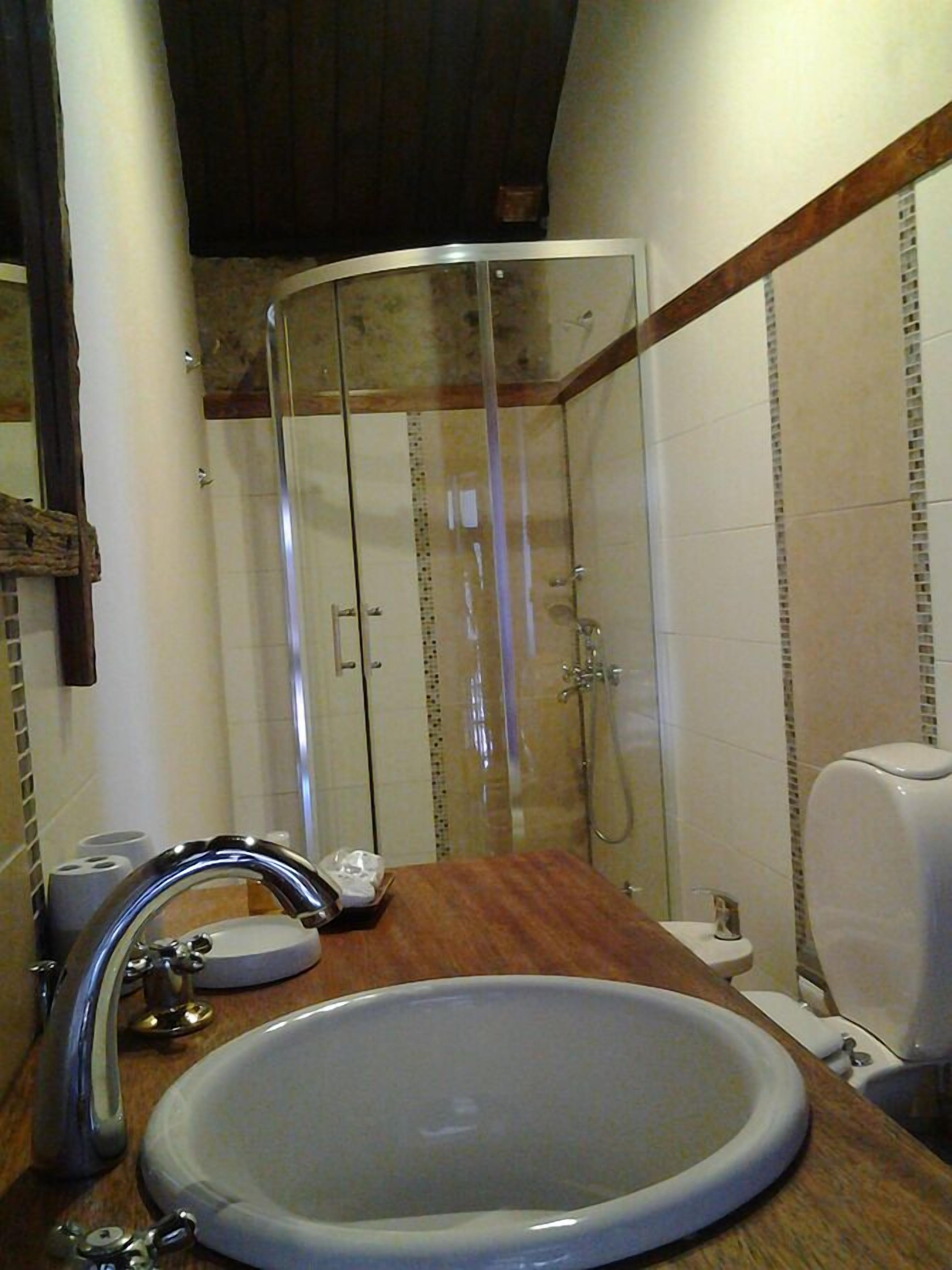 Une salle de bain équipée d’un lavabo, de toilettes et d’une douche à parois en verre.