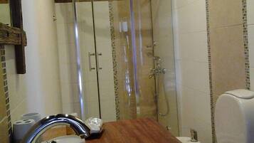 Une salle de bain équipée d’un lavabo, de toilettes et d’une douche à parois en verre.
