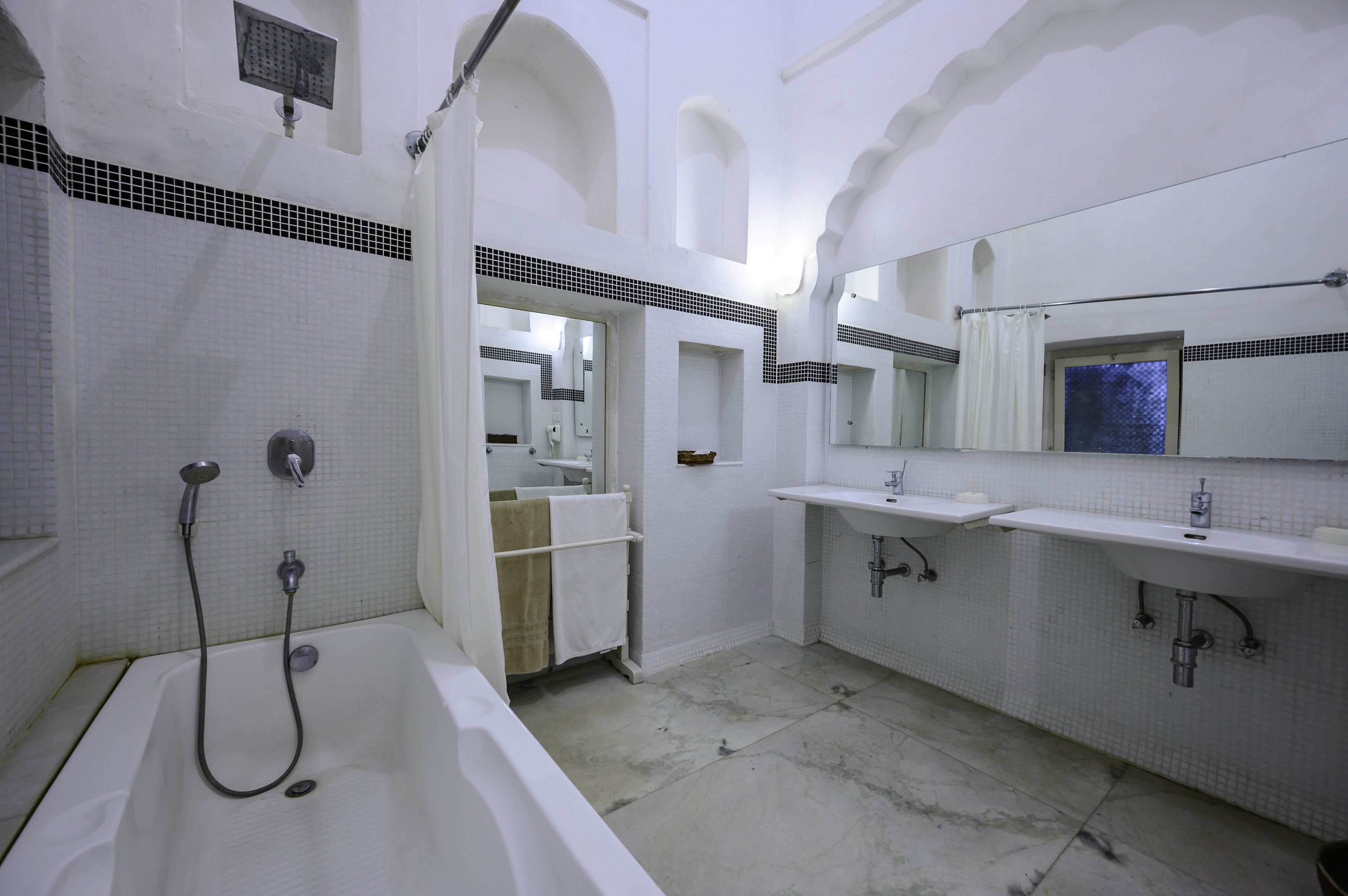 A bathroom with a bathtub, two sinks, and a shower.