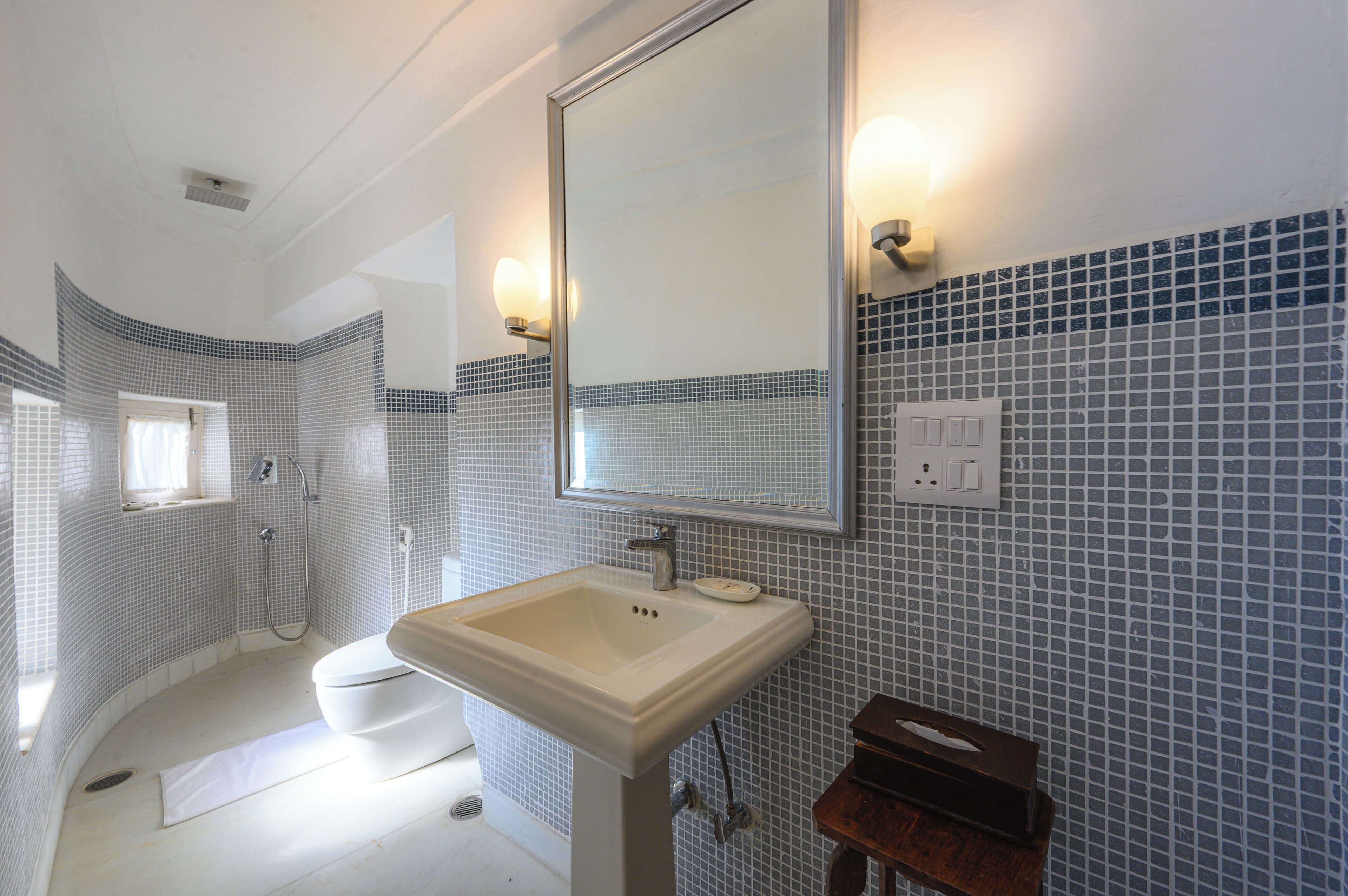 A bathroom with a white sink, a mirror, and a shower.