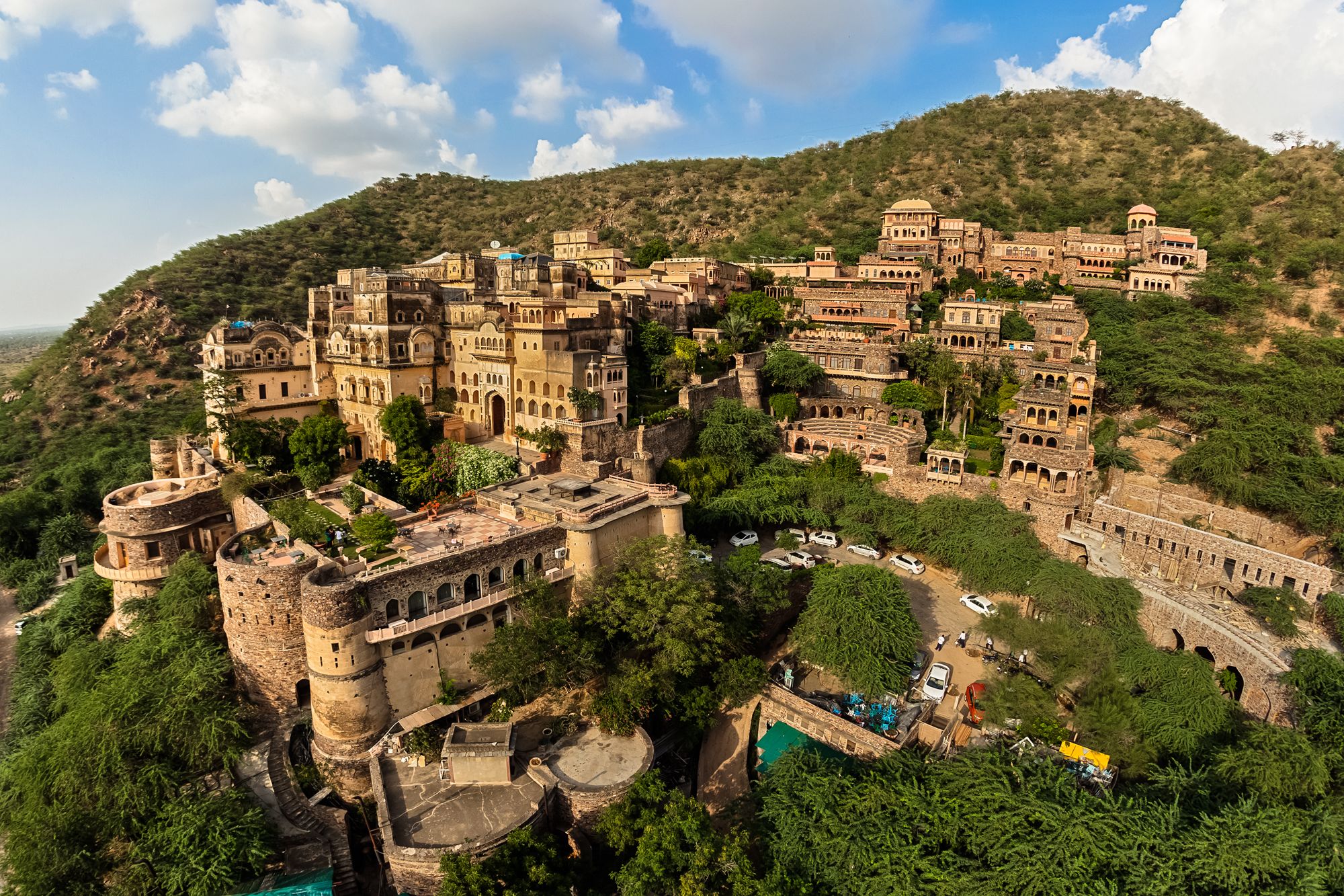 An ancient fortified town with multiple buildings, including a large central structure with a dome and smaller surrounding buildings.
