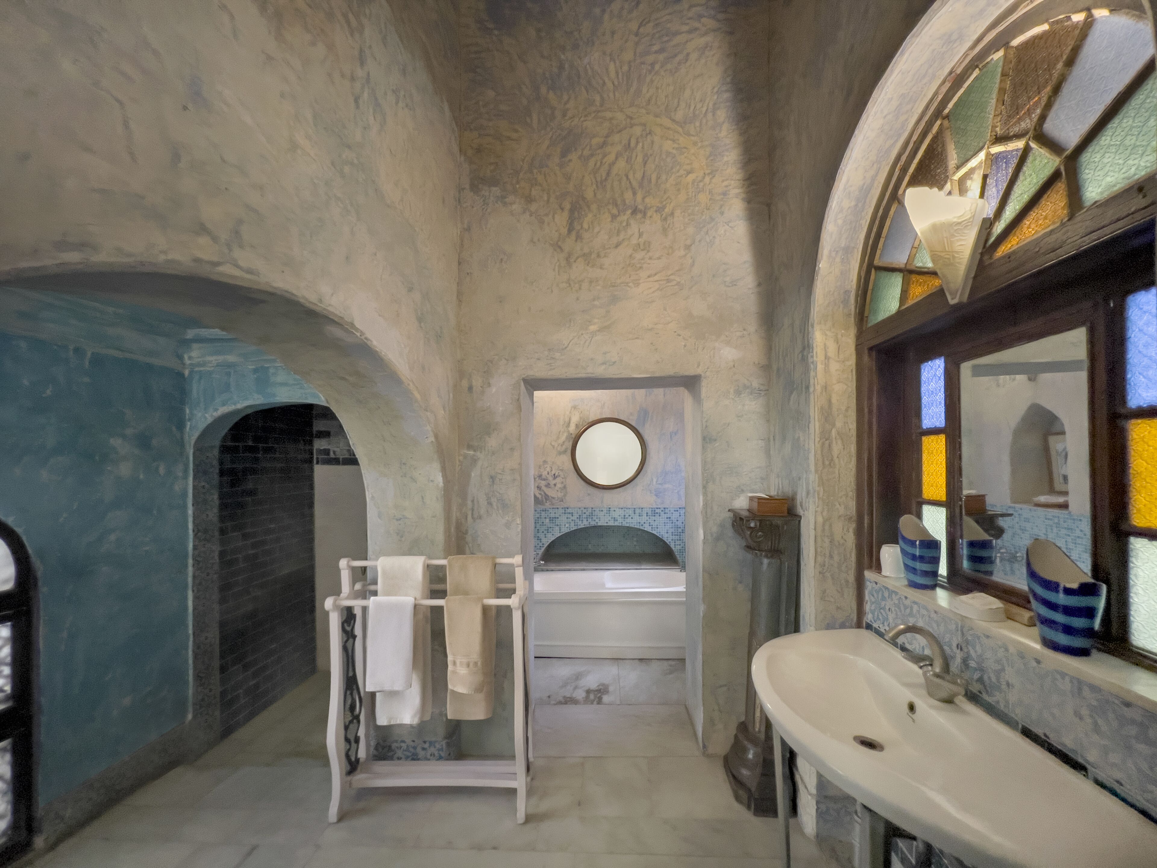 A bathroom with a bathtub, a sink, and a towel rack.