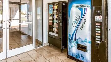 A cold drinks vending machine with a selection of beverages and a push button interface.