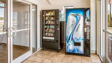 A vending machine area with a drink dispenser and a push vending machine.