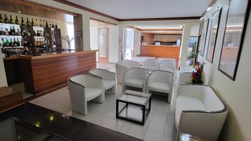 A modern interior with a bar area, seating, and a reception desk.