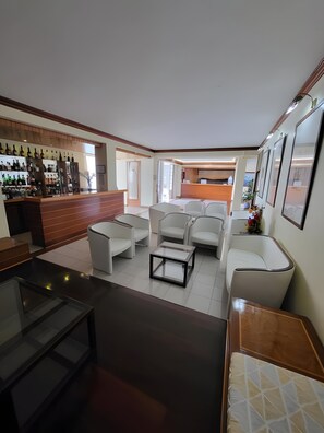 A modern interior with a bar area, seating, and a reception desk. - Hotel Beira Mar (Angra do Heroismo)