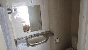 Une salle de bain équipée d’un lavabo, d’un miroir, de toilettes et d’une douche.