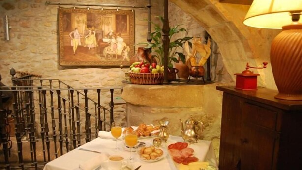 Une table de petit-déjeuner dressée avec divers aliments, un tableau accroché au mur et une lampe.