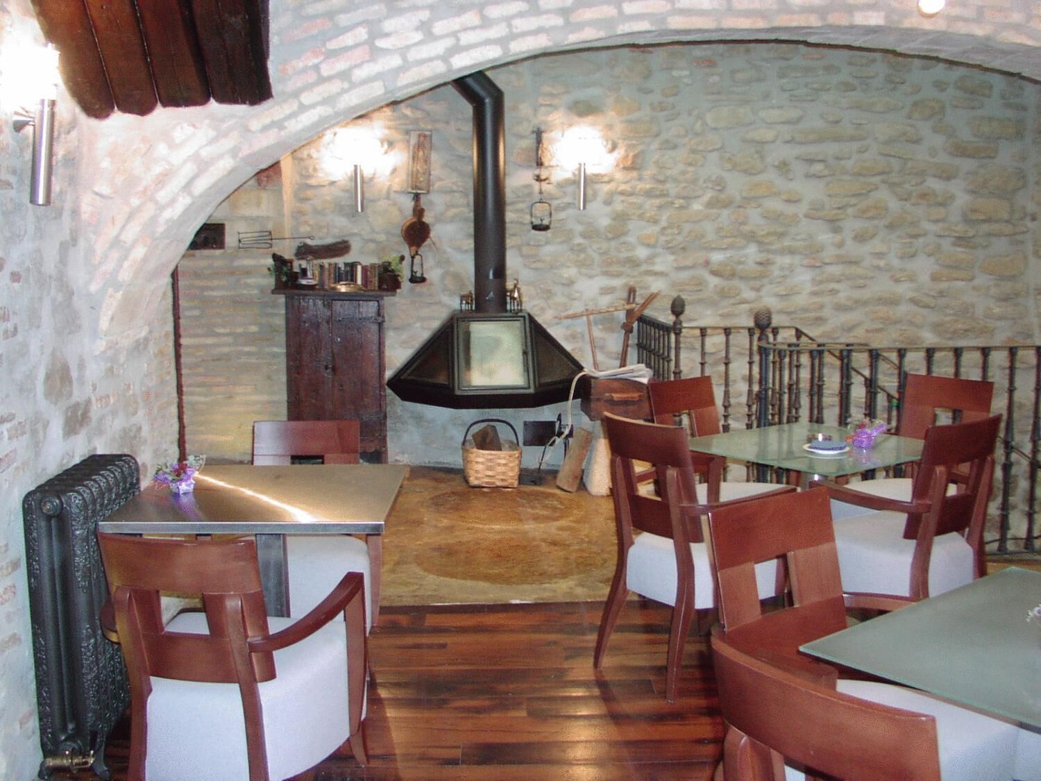 Un'accogliente sala da pranzo con pareti in pietra, un tavolo di legno e sedie.