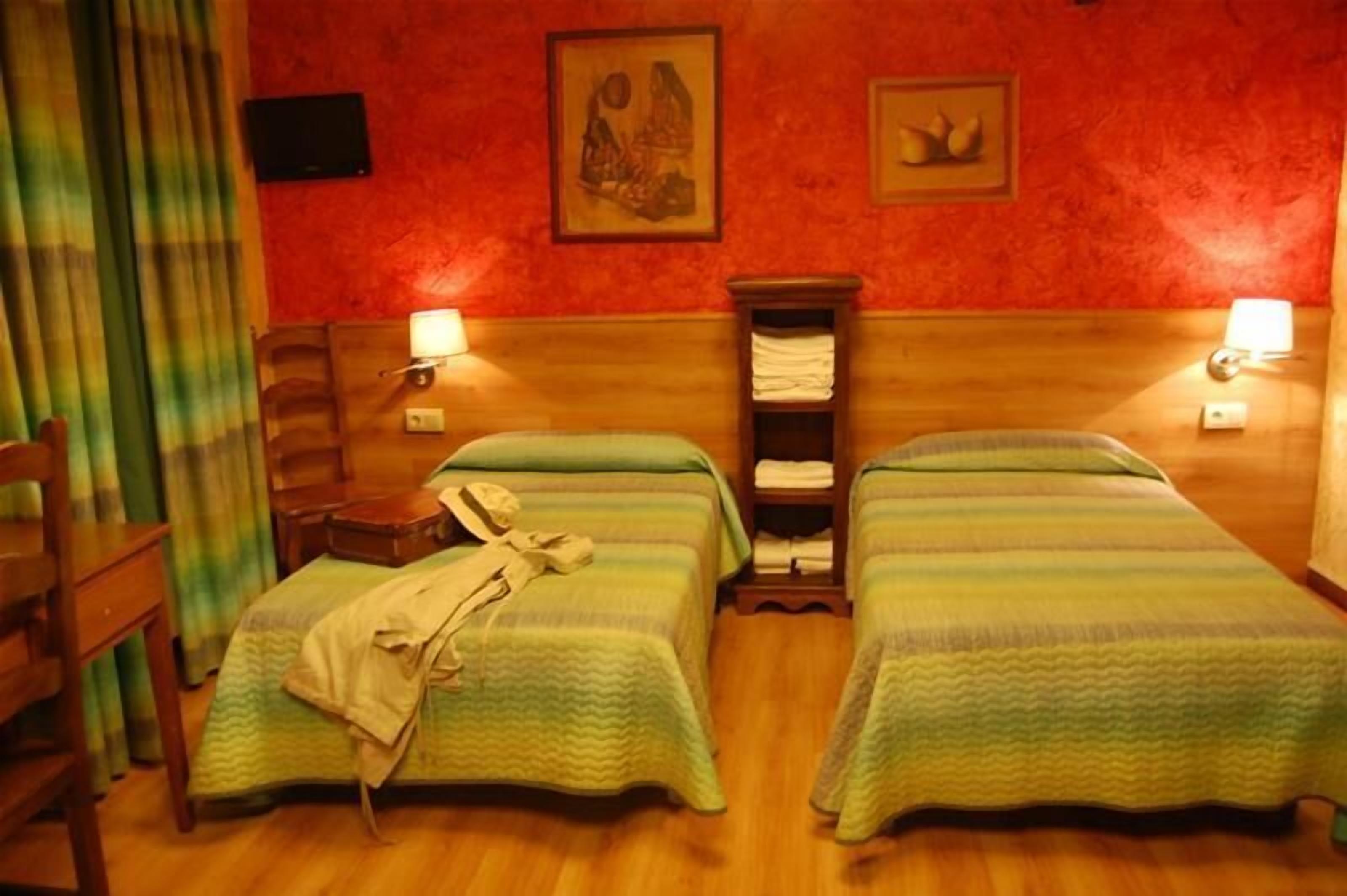 Ein Zimmer mit zwei Betten, Holz-Kopfteilen und Wandlampen.