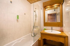 Un baño con bañera, lavamanos y espejo.