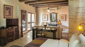 A bedroom with a bed, dresser, desk, chair, and a television. - Hotel Casa Mejía (Cartagena)