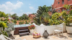 A rooftop terrace with a hot tub, lounge chairs, and potted plants. - Hotel Casa Mejía (Cartagena)