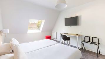 A modern hotel room with a large bed, a desk, a chair, a TV, and a window.