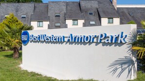 Een bord voor Best Western Armory Park, met een modern gebouw op de achtergrond.