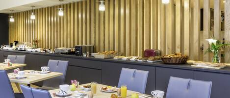 Un área de desayuno moderna con una barra alargada, asientos y diversas opciones para el desayuno.