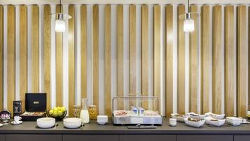 A buffet setup with various food items and a coffee station.