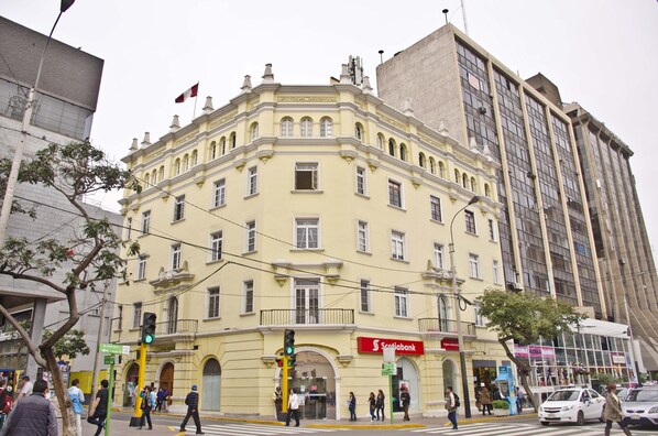 A historic building with a classic architectural style, featuring a prominent entrance and a flag on top. - Larq'a Park Rooms (Lima)